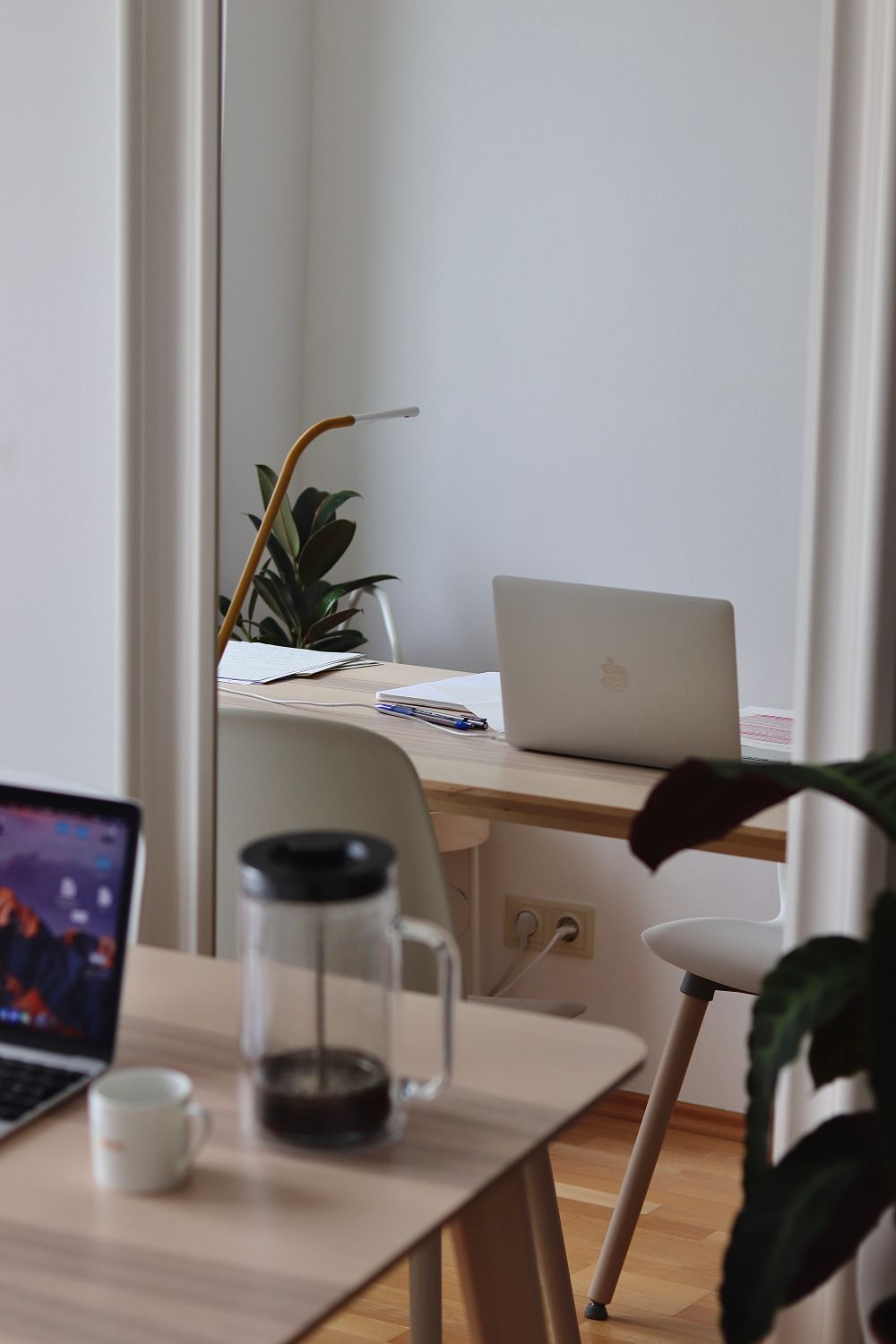 Laptops and coffee arranged on a wooden home office desk